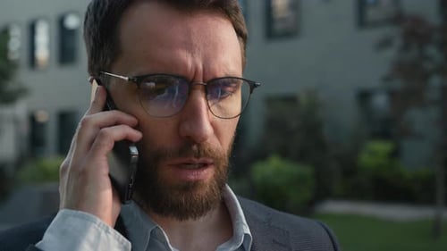 Serious Man Talking on Smartphone in City