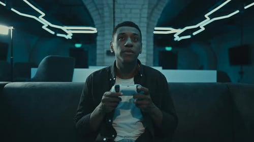 Focused Young Adult Playing Video Game at Night