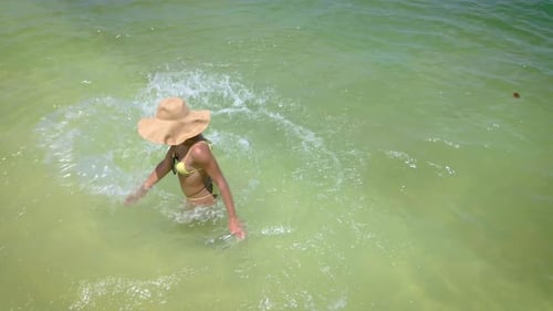 Woman Splashing in Tropical Ocean Water