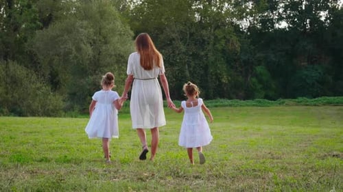 Mother and Daughters Walking in a Field
