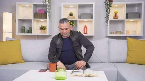 Man Coughing and Holding His Stomach in Discomfort