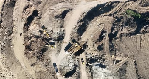 Industrial Mine Excavators are Digging the Soil in the Construction Site and Loading Trucks