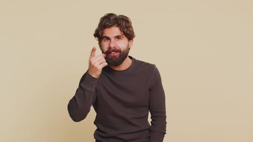 Lebanese Young Man Shakes Finger Saying No Be Careful Scolding Giving Advice on Beige Background