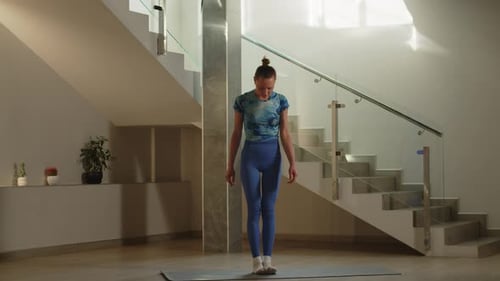 Woman Unrolls Yoga Mat and Completes Workout