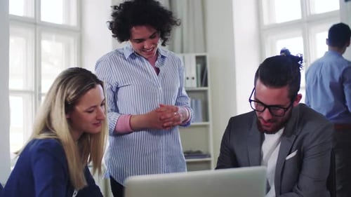 Jovem equipe de negócios colaborando em um projeto de computador em um escritório moderno