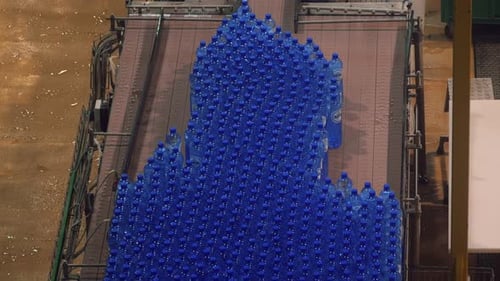 Effizienz in Flaschen: Plastikwasserflaschen auf dem Förderband in der Produktionsanlage