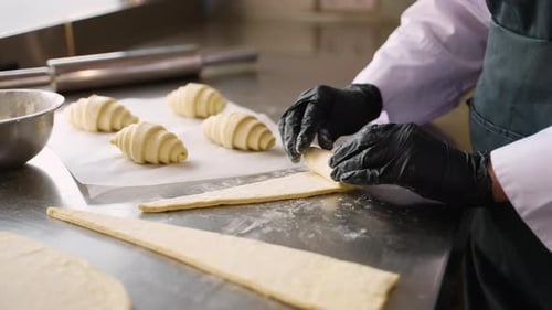Baker Rolling Dough to Make a Croissant