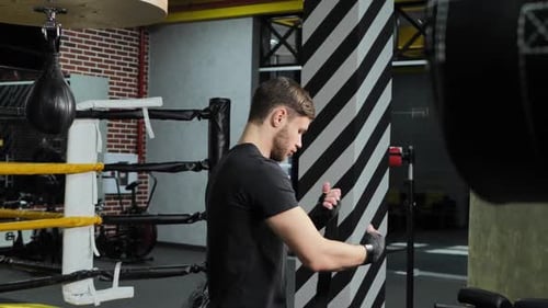 Man Wrapping Hands in Boxing Gym