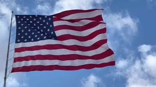 American Flag Waving Against Blue Sky