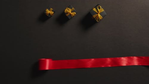 Gift Boxes with Red Ribbon on Dark Surface