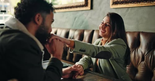 Romance, couple and kiss hand at restaurant for bonding together, admiration and connection