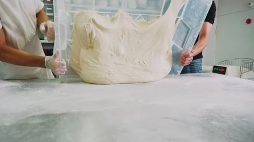 Bakers Put Large Dough Onto Table in Bakery Slow Motion