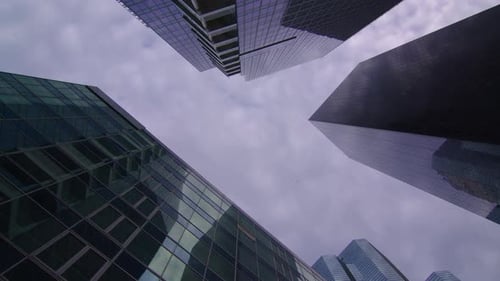 Die gläsernen Wolkenkratzer reflektieren den blauen Himmel mit Wolken