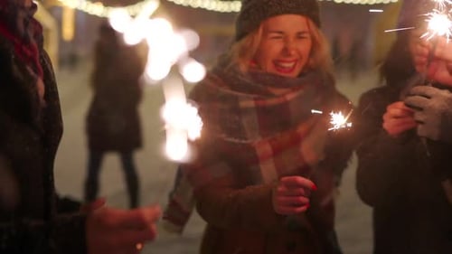 Friends Celebrate Christmas Holding Sparklers in Winter