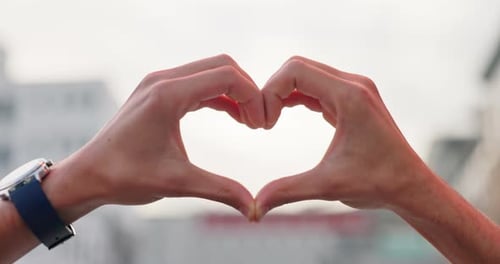 Hands Forming Heart Shape in Urban Setting