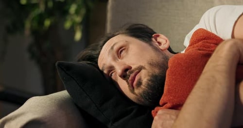 Man Sleeping Peacefully on Couch Indoors During Daytime