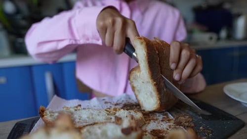 Woman Slices Bread in a Kitchen