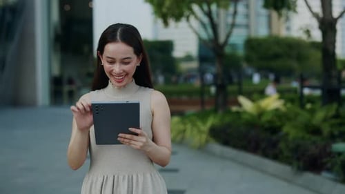 Smiling Woman Using Tablet in Modern Urban Setting