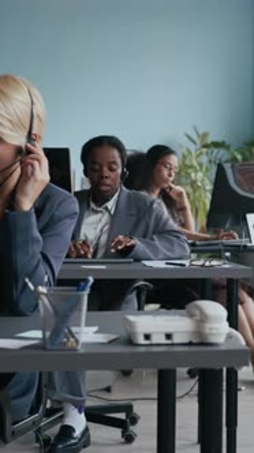 Operators Answering Questions of Customers in front of Computers by Desks