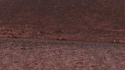 Convoy aéreo de cochecitos naranjas en las laderas volcánicas de Fuerteventura
