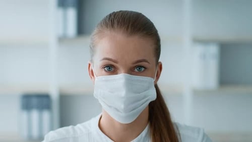 Young Businesswoman Wearing a Mask in a Modern Office Space