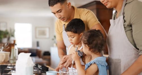 Family of Four Cooking Together in Kitchen