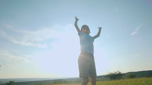 Young Boy Jumping for Joy in a Grassy Field