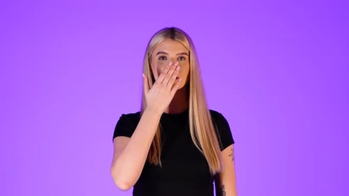 Attractive Blonde Woman Blowing a Kiss Towards Camera, Colorful Studio Portrait
