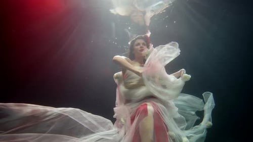 Elegant Woman Underwater in Flowing Dress and Flowers