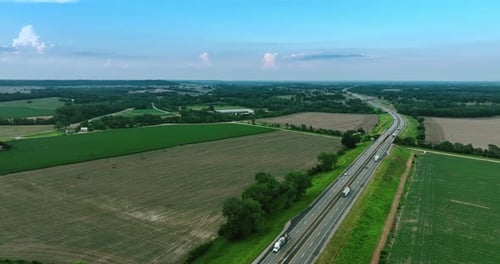 Lastwagen und Autos bewegen sich auf den beiden Autobahnen auf dem Land.
