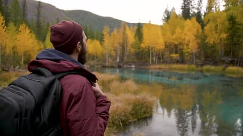 Traveler Man Stands in Picturesque Place of Wildlife and Looks at Majestic