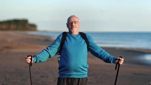 Smiling Elderly Man Grandfather Posing with Scandinavian Walking Stick at Sea Beach Sunset Closeup