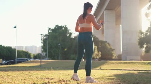 Sporty Woman Doing Warm Up Exercises at City Park During Sunny Day