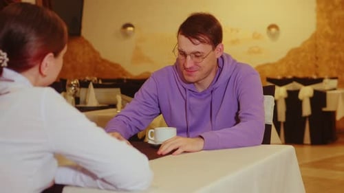 Woman and a Man are Talking in a Restaurant