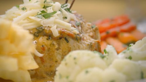 Mustard chicken with French fries, salad, and grated cheese, close-up, Mediterranean