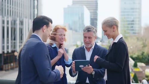 Business Team Collaborating With Tablet Outdoors