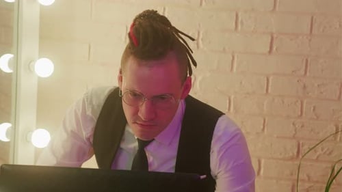 Young Adult Working at Laptop in Workplace