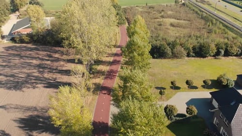 Tilt up aerial movement looking down upon a bicycle highway in The Netherlands in a suburban environ
