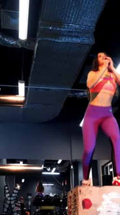 Fit athletic woman does box jumps in the fitness gym.