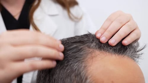 Doctor Examines Mature Man's Graying Hair