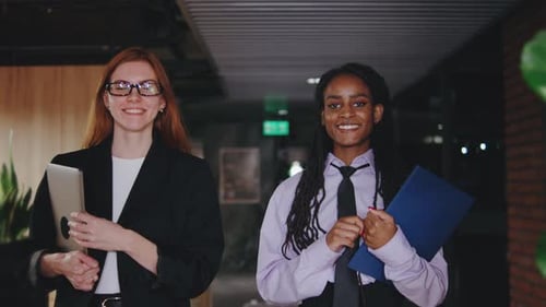 Smiling Colleagues Walking Through Modern Office