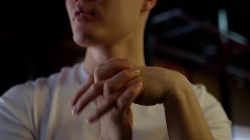 Young Adult Clasped Hands Impatiently in Dark