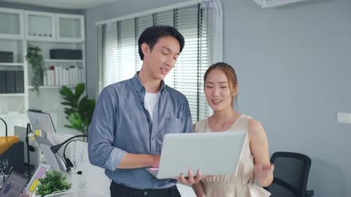 Young attractive businessman and businesswoman work in office workplace.