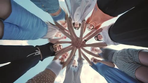 Group of Young Individuals Gathering in a Circle Linking Hands in an Outdoor Team Building Activity