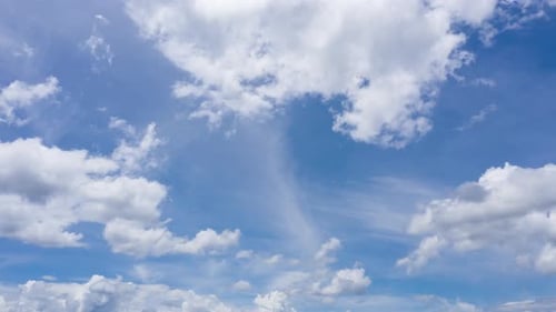 Fluffy Clouds Moving Across a Blue Sky