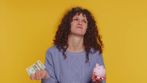 Poor Young Curly Haired Woman Insufficient Amount of Money Holding Piggybank and One Dollar Banknote