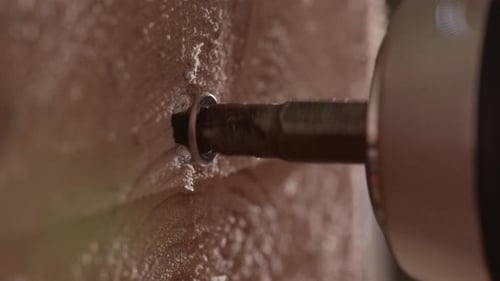 Carpentry Work With The Electric Screwdriver Unscrews A Screw. Macro Shot