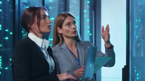 Women Inspecting Servers in Futuristic Data Center