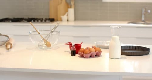 Camera is panning across bright kitchen countertop, showing baking ingredients ready for mixing