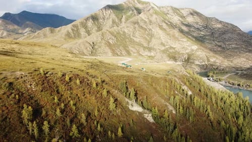 Sunlight Moving Over a Mountain Valley with a Turquoise River Flowing Through It There are Some
